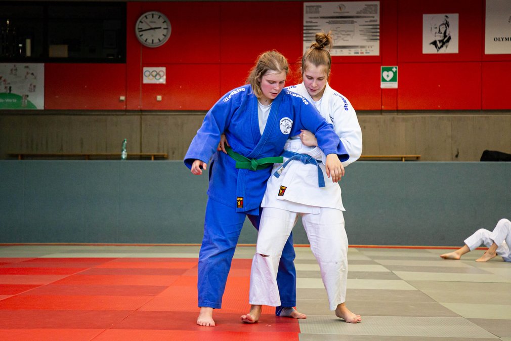 Zwei Judoka beim Training in einer Sporthalle.