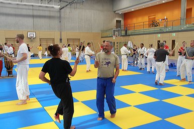 Momentaufnahme in einer Sporthalle in der zeitgleich viele Judoka trainieren.