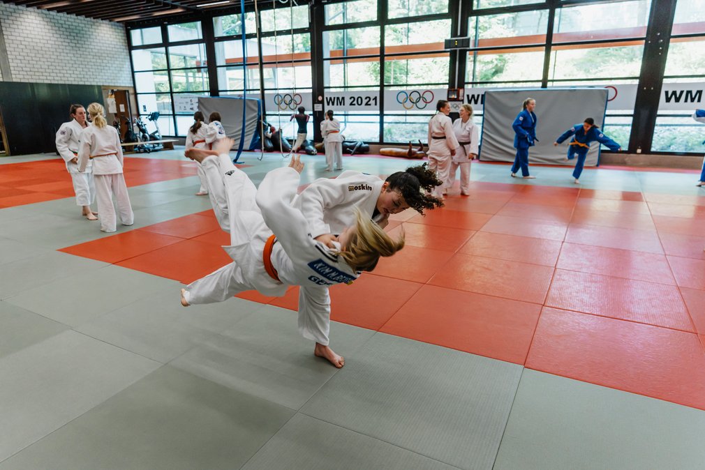 Zwei Judoka bei einem Trainingskampf im Ippon Girls Camp. Die eine wirft die andere zu Boden.