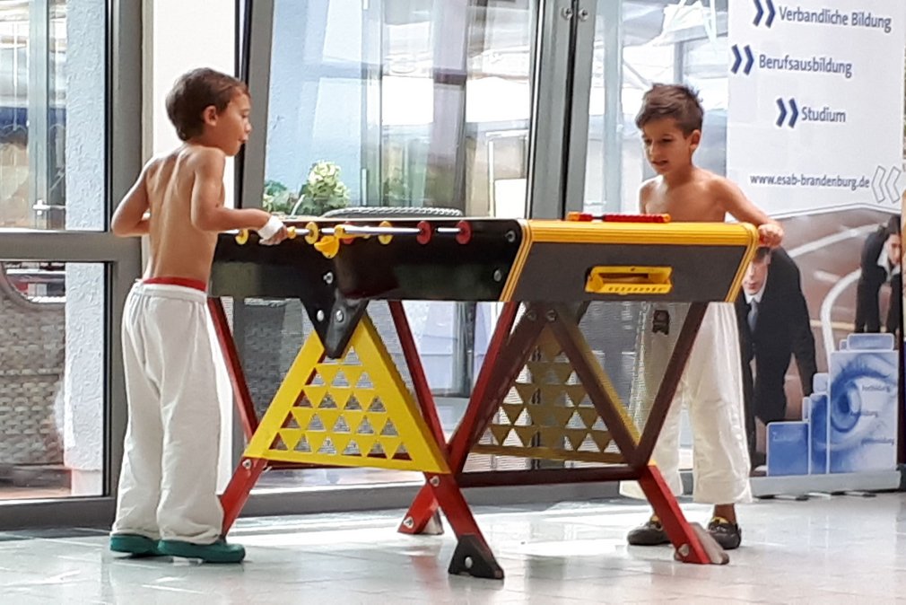 Zwei junge Judoka spielen Tischkicker.