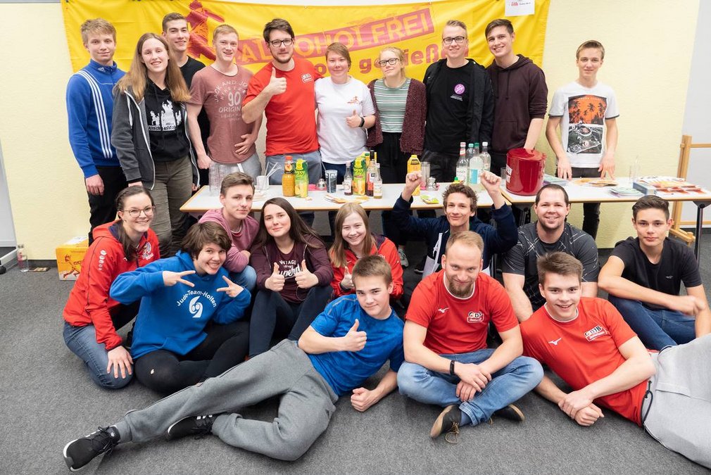 Eine Gruppe junger Judoka posiert bei einer Veranstaltung fuer ein Gruppenfoto.