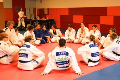Das Juniorteam sitzt im Kreis auf dem Boden und bespricht sich.
