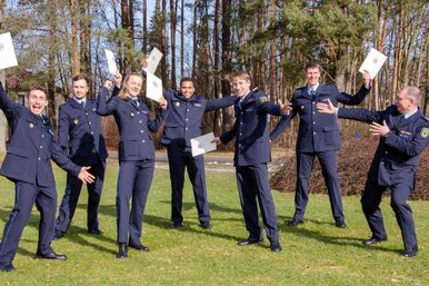 Judoka in Polizei-Uniform bejubeln ihre bestandenen Zertifikate.