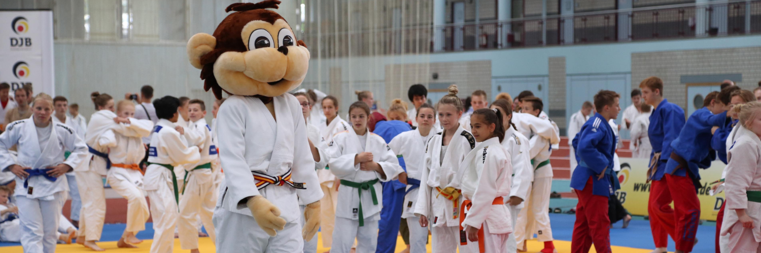 Das Maskottchen Yoko umgeben von jungen Judoka, bei einem Event des DJB.