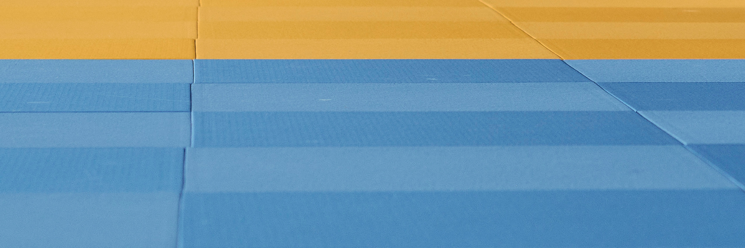 Eine Detailaufnahme von einer blau-gelben Judomatte